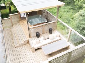 An outdoor area with a hot tub and seating at 24 Meadow Retreat in Dobwalls