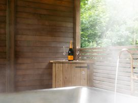 An outdoor spa area with a bottle of champagne and flutes at 24 Meadow Retreat Dobwalls