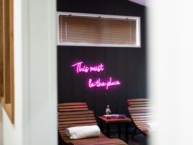 A spa area with lounge chairs and a neon sign at 24 Meadow Retreat in Dobwalls