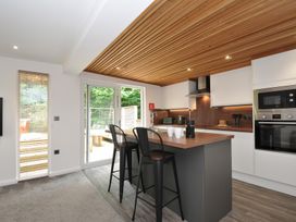 A kitchen with bar stools and appliances at 24 Meadow Retreat in Dobwalls