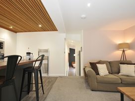 A living room with a sofa and bar stools at 24 Meadow Retreat in Dobwalls