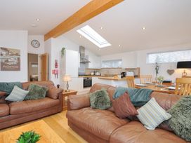 A living room with a kitchen area and dining table at 15 Faraway Fields in Dobwalls