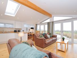 A living room with a sofa, table, and kitchen area at 15 Faraway Fields in Dobwalls
