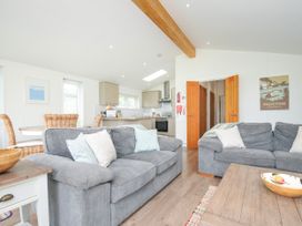 A living room with a sofa and kitchen area at 1 Horizon View Dobwalls