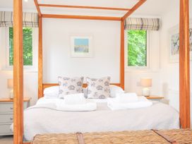 A bedroom with a four-poster bed and bedside table at 1 Horizon View in Dobwalls