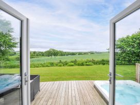 An outdoor area with a wooden deck and hot tub at 1 Horizon View in Dobwalls