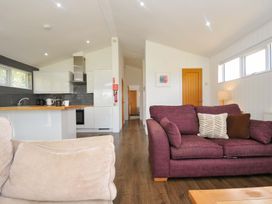 A living room with a sofa and kitchen area at 3 Horizon View in Dobwalls