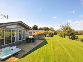 A garden with a deck, hot tub, table, and chairs at 3 Horizon View in Dobwalls