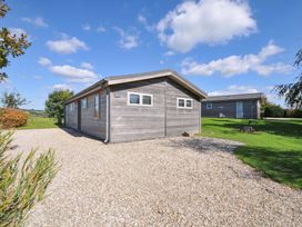 A wooden house with a gravel driveway and grass at 3 Horizon View, Dobwalls
