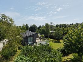 A house with a deck surrounded by trees and grass at 11 Meadow Retreat in Dobwalls