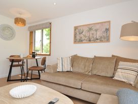 A living room with a sofa and dining area at 12 Meadow Retreat in Dobwalls