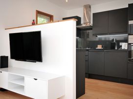 A kitchen with a television and kitchen cabinets at 12 Meadow Retreat in Dobwalls