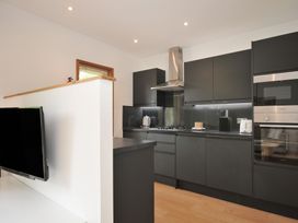 A kitchen with modern appliances and a television at 12 Meadow Retreat in Dobwalls