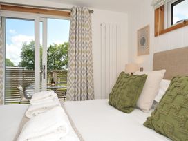 A bedroom with a bed and sliding door to a balcony at 12 Meadow Retreat in Dobwalls