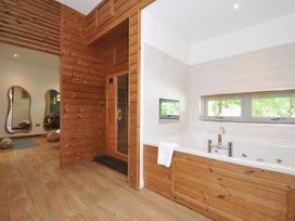 A bathroom with a bathtub and sauna at 12 Meadow Retreat in Dobwalls