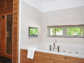 A bathroom with a bathtub and sauna at 12 Meadow Retreat in Dobwalls