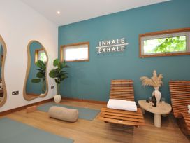 A yoga room with wooden chairs and mats at 12 Meadow Retreat in Dobwalls