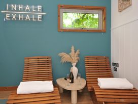 A spa room with lounge chairs and a decorative plant at 12 Meadow Retreat in Dobwalls