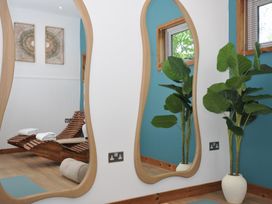 A spa room with wooden chairs and large mirrors at 12 Meadow Retreat in Dobwalls