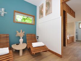 A spa area with wooden chairs and a table at 12 Meadow Retreat in Dobwalls