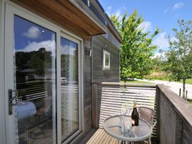 An outdoor area with a glass table and champagne at 12 Meadow Retreat in Dobwalls