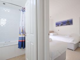 A bathroom with a bathtub and a view into a bedroom at 10 Horizon View in Dobwalls