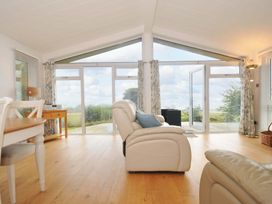 A living room with large windows and a chair at 11 Horizon View in Dobwalls