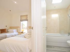 A bedroom with twin beds and a bathroom with a bathtub at 11 Horizon View Dobwalls