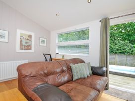 A snug with a brown leather sofa and a window at 15 Horizon View in Dobwalls