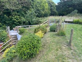 A garden with a path, plants, stairs, and a bench at Delfryn, Newport
