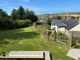 A garden area with a bench and a view of houses at Delfryn, Newport