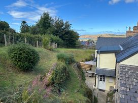 A garden with a table and chairs next to a house at Delfryn, Newport