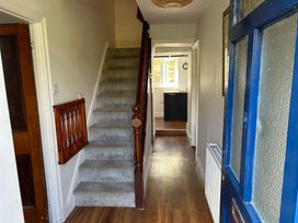 A hallway with a staircase and door at Delfryn, Newport