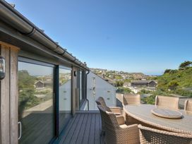 An outdoor dining area with a table and chairs at Breakers View in Polzeath