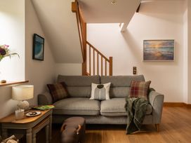 A living room with a sofa and a lamp at Hoppers Barn in Pancrasweek near Holsworthy