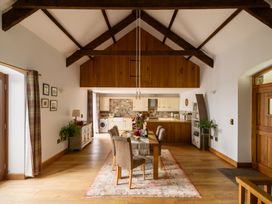 A dining room with a wooden table and chairs at Hoppers Barn in Pancrasweek near Holsworthy