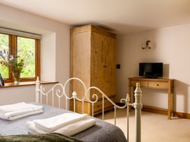A bedroom with a bed and wardrobe at Hoppers Barn Pancrasweek near Holsworthy