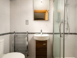 A bathroom with a sink, shower, and towel rail at Hoppers Barn near Holsworthy