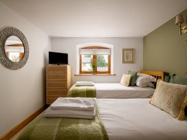 A bedroom with two beds and television at Hoppers Barn Pancrasweek near Holsworthy