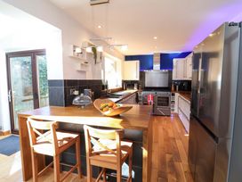 A kitchen with bar stools and stainless steel appliances at Hillsview in Combe Martin