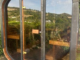 A structure with a glass door and benches at Hillsview in Combe Martin