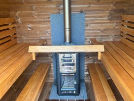 A sauna with wooden benches and a stove at Hillsview in Combe Martin