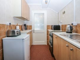 A kitchen with appliances and cabinets at First Floor Apartment in Tremadog