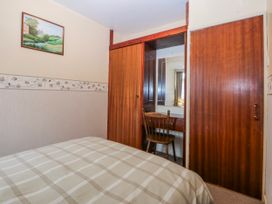 A bedroom with a bed and a chair at First Floor Apartment Tremadog