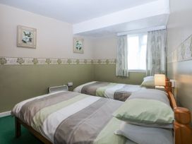 A bedroom with two beds and a window at First Floor Apartment in Tremadog