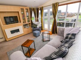 A living room with a TV and shelves at Reef Retreat in Little Haven