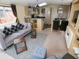 A living room with a sofa and dining area at Reef Retreat in Little Haven