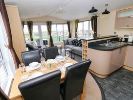 A dining room with a table set for meals and a sofa at Reef Retreat in Little Haven