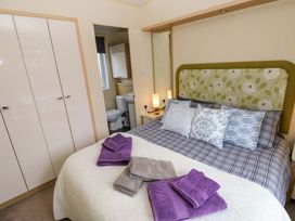 A bedroom with a bed and wardrobe at Reef Retreat in Little Haven