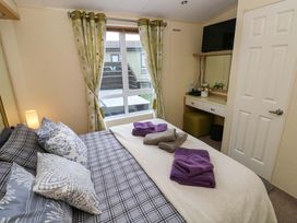 A bedroom with a bed and towels at Reef Retreat in Little Haven